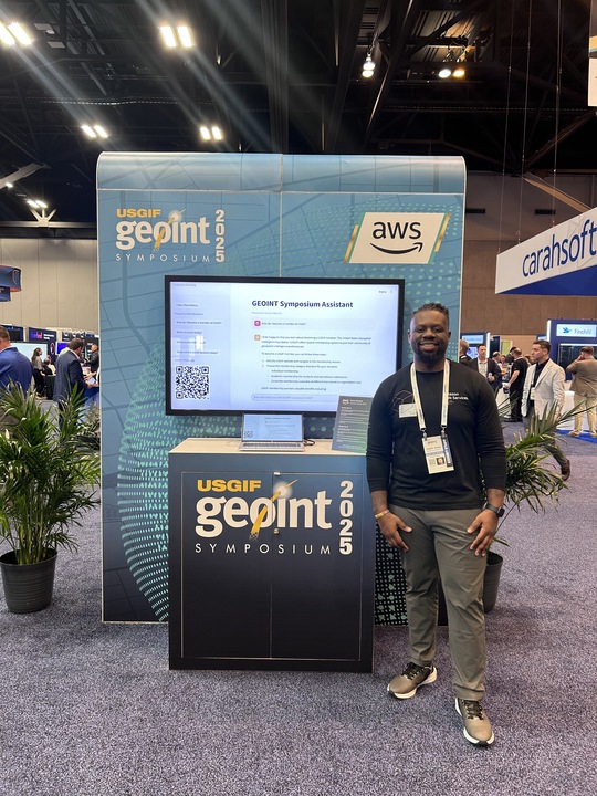 Jordan Jones at GEOINT Symposium 2025 AWS booth with chatbot demo
